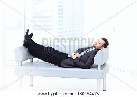 Satisfied businessman relaxing in his modern office