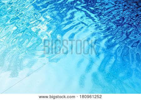 Photo of a blue bright water texture in a river with sun glares