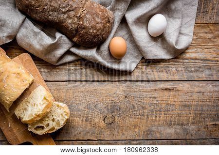 bakery concept with homemade fresh wheat and rye bread on rustic kitchen table background top view moke-up