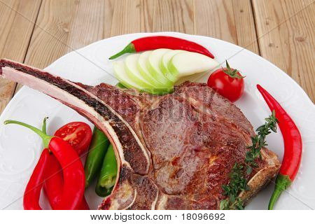 santoreggia: alla griglia ricambio rib su piatto bianco con pepe timo e pomodoro sul tavolo di legno