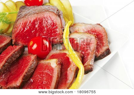半生的牛肉肉与蔬菜在白板上。浅景深