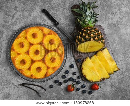 Homemade fruit pineapple pie cake. Ingredients for pineapple blueberry pie cake strawberry fresh cut into pieces of pineapple vanilla. Gray concrete background.