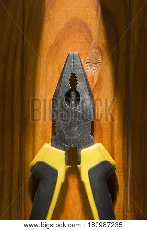 Close up of a multitool pliers on wooden background