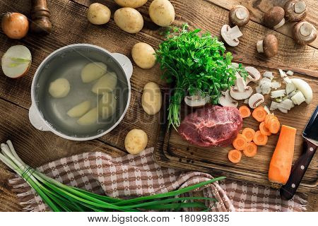 Ingredients for cooking soup on wooden table top view. Raw ingredients for prepared healthy food.