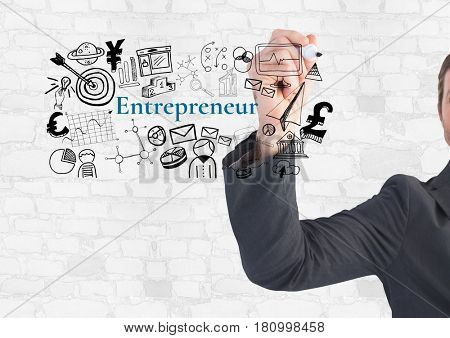 Digital composite of Businessman writing Entrepeneur text with drawings graphics
