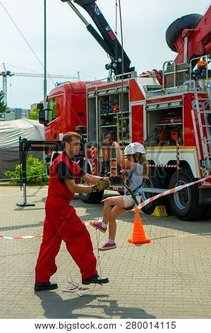Poznan, Poland - June 9, 2018: Firefighter Assisting Girl Climbing A Hanging Ladder During The Bezpi