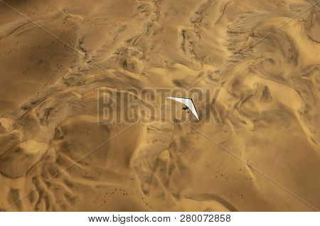 An Ultralight Aircraft Can Be Seen Flying Over The Sands Of Namibia