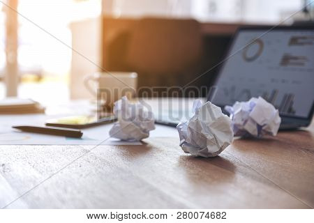 Closeup Image Of Laptop, Mobile Phone And Screwed Up Papers On Wooden Table In Office