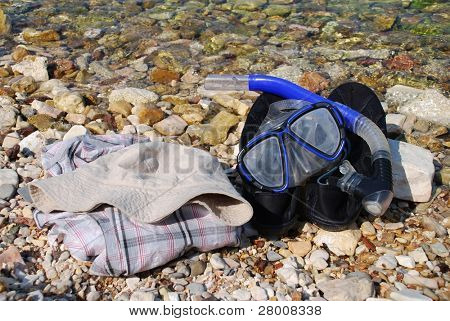 Un tuba et un masque pose à côté d'une chemise et bloquent sur la plage de galets à Spilia Bay sur le grec 