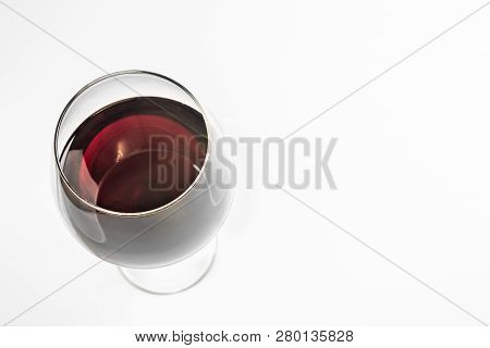 Glass Of Red Wine, Copy Space, Isolated. Spanish Emerald Wine In A Glass With A High Stem.