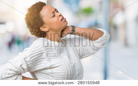 Beautiful young african american woman wearing sweater over isolated background Suffering of neck ache injury, touching neck with hand, muscular pain