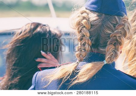 Woman With Pigtails In Uniform In A Forage-cap. Rear View