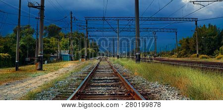 Railway Tracks Go Under The Stormy Sky.