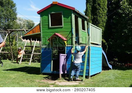 Dobrzyca, Poland - August 6, 2018: Boy Trying To Climb On A Colorful Wooden Hut At A Playground In T