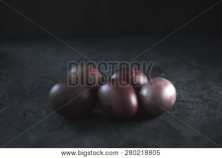 Dark Purple Eggs On A Rough Cement Background.