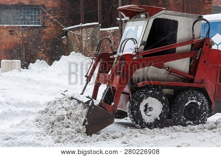 Small Snowblower Clears Snow From The Street After A Big Snowstorm, Shoveling Snow In The Ladle/ Sno