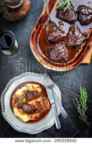 Traditional German braised veal cheeks in brown sauce with mashed potatoes as top view on a pewter plate