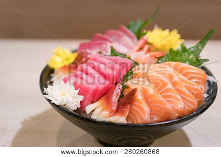 Mixed Sliced Fish Sashimi On Ice In Black Bowl. Sashimi Salmon Tuna Hamachi Prawn And Surf Calm Set,