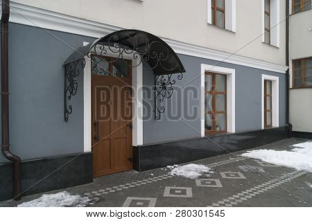 Wooden Door With A Metal Canopy, Windows, Drainpipes And Walls Of The Temple