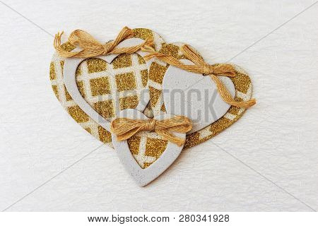 White Patterned Background With Golden Hearts. Three Gilded Hearts In The Center Of The Frame. Copy 