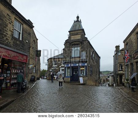 Howarth, West Yorkshire, England - 12 September 2018: Tourists Walking With Umbrellas On A Rainy Day