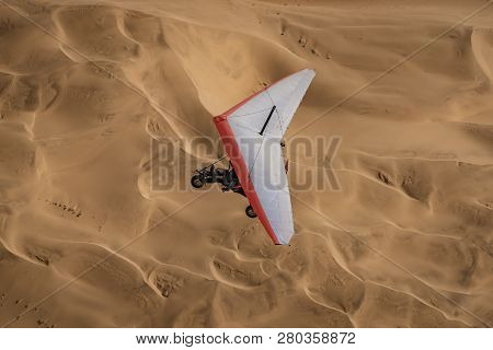 Walvis Bay, Namibia - July 16, 2018: An Ultralight Aircraft Is Seen Flying With Sand Dunes As A Back