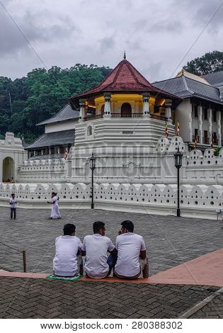 Kandy, Sri Lanka - Dec 15, 2018. Local Young Men Sitting At Temple Of The Sacred Tooth Relic In Kand