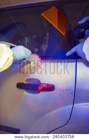 Crime Investigation - Developing Of Fingerprints On Suspected Car In Police Garage Under Uv Light
