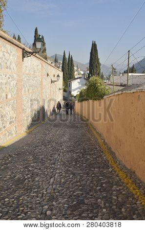 Granada, Spain - December 27, 2014: People Strolling At Narrow Stone Pavement Footpah In The Medieva