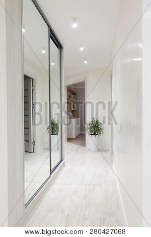 Interior Of Bright Coridore Home. Mirror On Left Side.