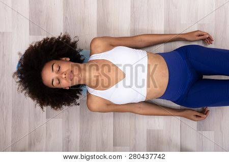 High Angle View Of A Young Woman Doing Workout On Exercise Mat