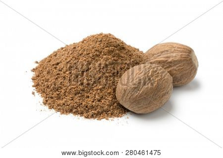 Heap of ground nutmeg and whole nutmeg seeds isolated on white background