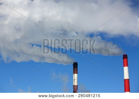 White Smoke Comes From Pipes Against Blue Sky. Problem Harmful Emissions And Air Pollution Of Centra