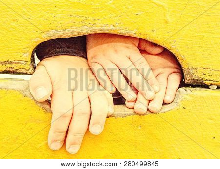 Children Hand With Small Fingers. Hand And Footholds On A Wooden Outdoor Climbing Wall.