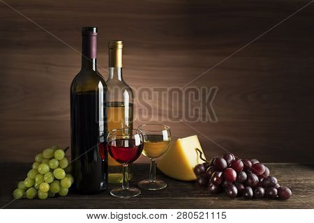 Glass And Bottle Of Red And White Wine On Wooden Background