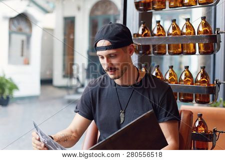 Close Up Portrait Of Young And Popular Food Blogger Attentively Reading Menu Of Brand New Restaurant