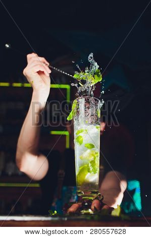 Mojito Cocktail At The Bar. Bartender Preparing Mojito. Barman Making Cocktail With A Lot Of Ice And