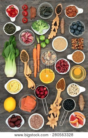 Health food to slow the ageing process concept including fruit, vegetables, fish, nuts, herbs, spice, dairy, pollen grain and  supplement powders. High in antioxidants, anthocyanins & dietary fibre. 