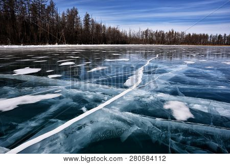 Frozen Lake Khubsugul. Beautiful Forest Near The Ice Surface On A Frosty Day. Natural Background