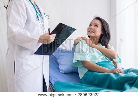 Women Doctor Reassuring Her Female Asian Patient In Hospital Room,dentist Giving A Consultation And 