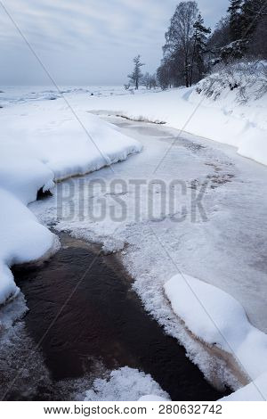 Winter Forest On The River At Sunset. Colorful Landscape With Snowy Trees, Beautiful Frozen River Wi