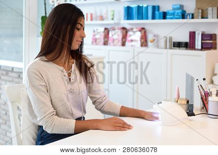 Woman Using Manicured Nails In Uv Lamp. Small Nail Art And Manicure Business. Hands Of Woman In A We