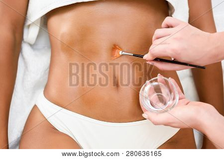 Woman Receiving Belly Massage Treatment With Oil Brush