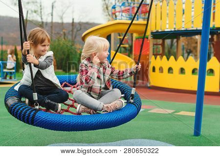 Happy Kids Having Fun On Playground Outdoors. The Best Girl Friends Playing Together. Modern Colorfu