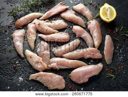 Raw Chicken Breast Mini Fillets In Rastic Cast Iron Skillet, Frying Pan With Herbs And Sea Salt