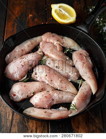 Raw Chicken Breast Mini Fillets In Rastic Cast Iron Skillet, Frying Pan With Herbs And Sea Salt