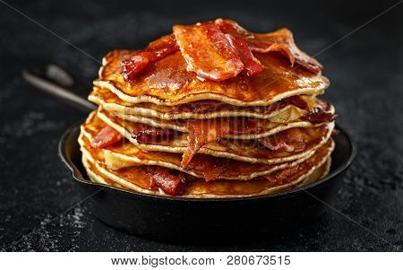 Pancakes With Crispy Bacon And Maple Syrup In Cast Iron Skillet, Frying Pan. Morning Breakfast
