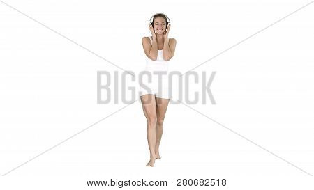 Happy Girl In Leisure Ware Listening Music And Walking On White Background.