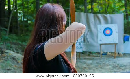 Medieval Female Archer Shooting Targets With Wooden Bow At Historical Festival. Archery And Medieval
