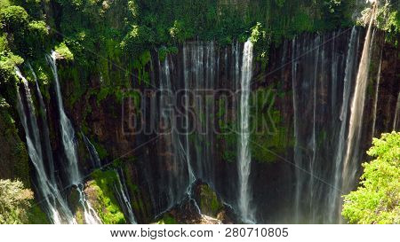 Waterfall Coban Sewu In Tropical Forest, Java Indonesia. Tumpak Sewu Waterfall In Rainforest Aerial 